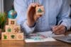 Man holding wooden blocks featuring eco-friendly symbols representing key aspects of sustainability.