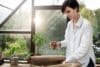 A woman holds a plant pot inside a paper bag, showcasing her love for plants and nature.