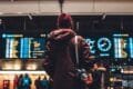 A man in a red coat stands at an airport, symbolizing the surge in American travel post-pandemic.