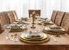 A beautifully set dinner table with elegant dishes and a wicker chair, showcasing Ashley Furniture dining sets.