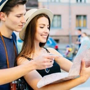 Young couple exploring Bali, studying a map while walking through the vibrant city streets.