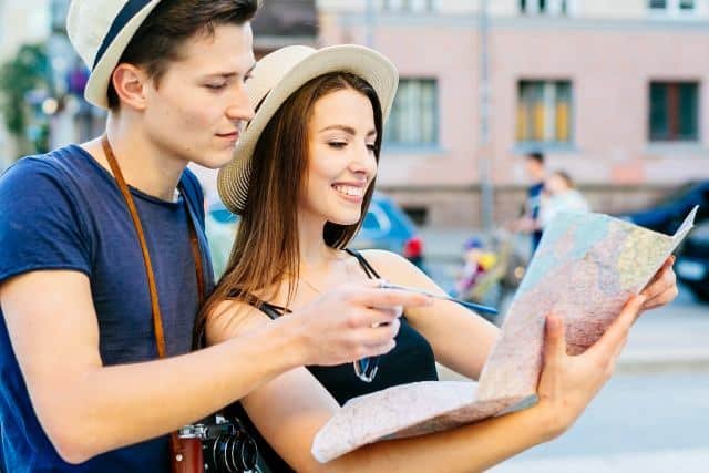 Young couple exploring Bali, studying a map while walking through the vibrant city streets.