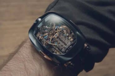 A man showcases a Bugatti watch featuring a visible mechanical skeleton design on the dial.
