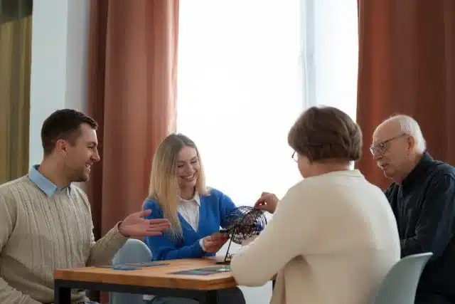 Three young friends playing a board game at a daycare table, smiling and focused on their game.