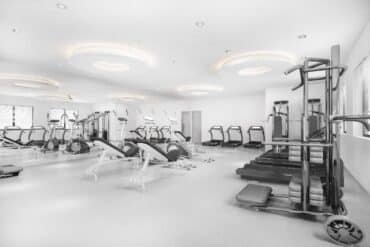Black and white photo of a gym room at Delta Fitness Authority, showcasing workout equipment and an open space.