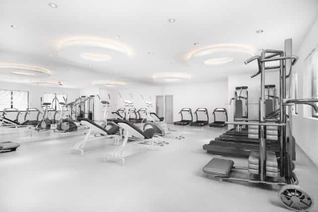 Black and white photo of a gym room at Delta Fitness Authority, showcasing workout equipment and an open space.