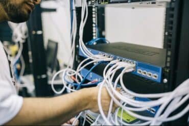 A man works on a server in a data center for Diamond Communications, focused on maintaining the equipment.