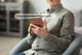 Elderly man engaged with a tablet computer, exploring digital content on DigitalConnectMag.com.