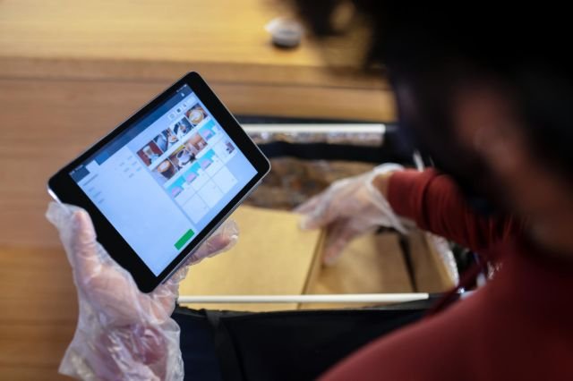 A person holding a tablet computer in their hand, focused on the screen.