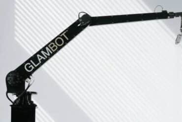 A black and white image of a crane with the word "glambot" painted on it, showcasing industrial art.