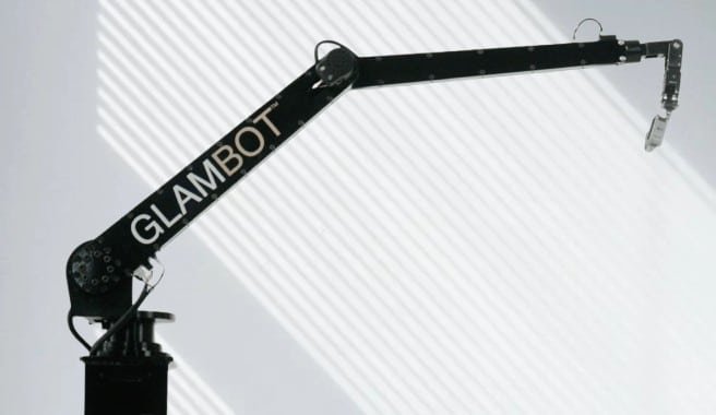A black and white image of a crane with the word "glambot" painted on it, showcasing industrial art.
