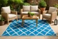A stylish blue outdoor rug with white and blue details, ideal for patios or gardens.