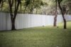 A metal privacy fence stands in the center of a lush grassy area, providing a boundary in the open space.