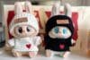 Two cute stuffed animals adorned with hearts, showcasing Labubu Clothing's playful style.