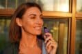 A smiling woman holds a purple Fume vape, showcasing her enjoyment of the electronic cigarette.