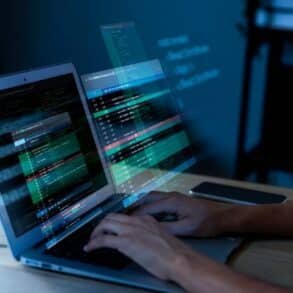 A person typing on a laptop, working with Microsoft Dynamics 365 software.