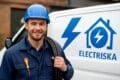 Electrician standing in front of a van with "Närkes Elektriska" sign, ready to assist with electrical services.