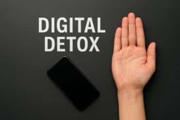 Hand resting on a black table, symbolizing a digital detox and a break from technology.