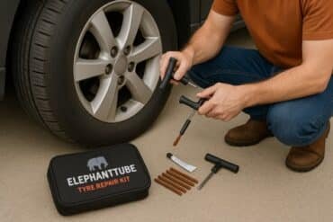 A person repairing a flat tire with the ElephantTube kit, hands on tyre, tools and patches nearby, in daylight.