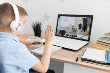 A student engaging in K12 online learning with a laptop and digital resources.