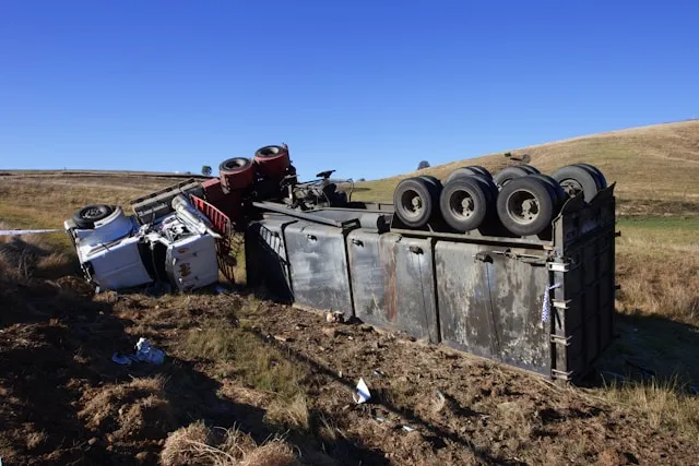 An overturned truck lies on the roadside, indicating a recent accident for investigation purposes.
