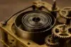 Close-up of an antique clock's inner mechanism, featuring a spiral mainspring and intricate gears in brass and steel.