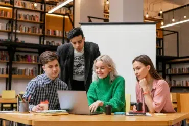 A group of young people collaborating on a laptop in the RGUKT Hub library