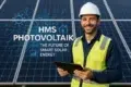 A worker in a hard hat and safety vest holds a tablet in front of solar panels, highlighting advancements in solar energy technology.