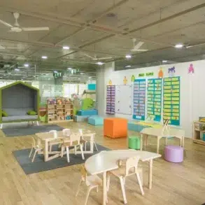 Bright, spacious classroom with colorful furniture, play areas, and educational displays, designed for early childhood learning.