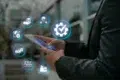 A person in a suit uses a smartphone, surrounded by glowing digital icons related to supply chain management, like gears and delivery trucks, symbolizing efficiency.