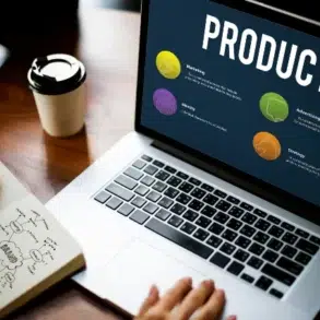 Laptop displaying a product strategy presentation with four colored icons, next to a notebook with diagrams and a coffee cup. Collaborative and focused atmosphere.