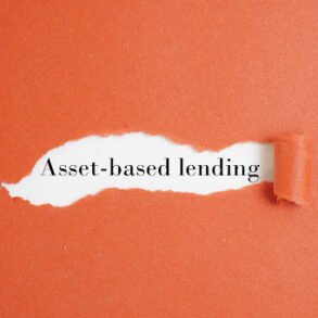 A torn orange paper reveals the phrase "Asset-based lending" in black text on a white background, evoking a theme of financial discovery.