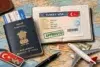 A map with an Indian passport, a Turkish keychain, a flight ticket, currency, and an open passport displaying an approved Turkey visa, alongside a toy airplane.