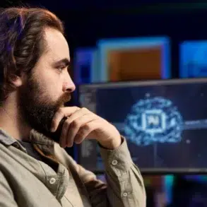 Person in casual clothing sitting thoughtfully in front of computer screens displaying a digital brain and code in a dimly lit room.