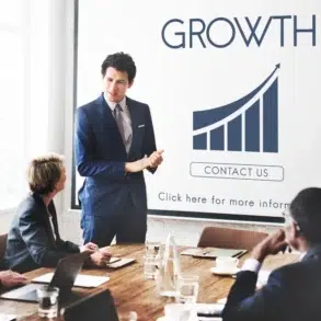 A business presentation in a modern conference room, with a speaker discussing growth strategies and a chart displayed on a screen.