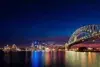 Sydney Harbour at night with the Harbour Bridge and Opera House illuminated against the city skyline