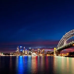 Sydney Harbour at night with the Harbour Bridge and Opera House illuminated against the city skyline