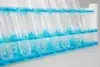Clear empty test tubes held in a blue plastic rack, arranged in rows on a white surface in a laboratory setting.