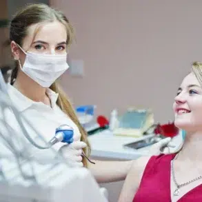 A healthcare professional uses a device on a patient's arm in a clinical setting, focusing on a cosmetic treatment.
