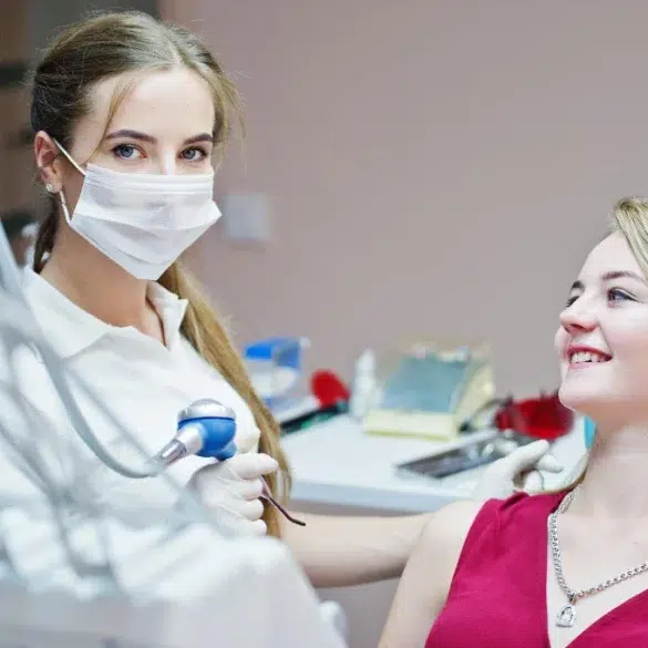 A healthcare professional uses a device on a patient's arm in a clinical setting, focusing on a cosmetic treatment.