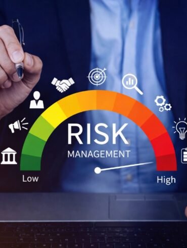 A person in a suit holds a pen above a risk management gauge, ranging from low to high, with business icons. The tone is professional and analytical.