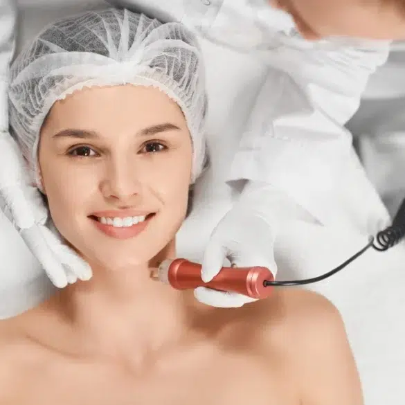 A skincare professional performs a treatment on a client's neck using a handheld device in a clinical setting.