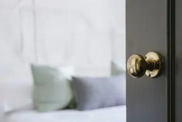 A close-up of a classic brass door knob on a dark wooden door, highlighting the elegance and timeless appeal of wooden door handles in home interiors.