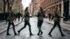A woman in a green jacket and jeans is shown in four walking poses on a wet city street. The background features blurred city buildings and pedestrians.