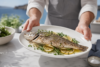 Whole Branzino Fish roasted with lemon, herbs, and olive oil on a serving platter