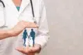 A doctor with a stethoscope holds an illustrated family silhouette, symbolizing healthcare. The image conveys protection and care in a soft, reassuring tone.