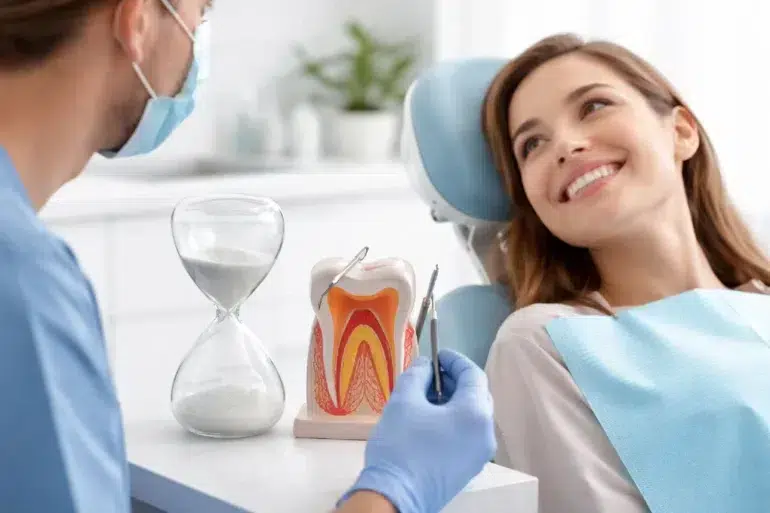 A dental professional performing a root canal procedure on a patient to explain how long does a root canal take.