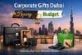 Corporate gifts ad featuring a Dubai skyline at sunset. Includes luxury items like a leather briefcase and wine, and budget items like a tote bag and notebook.