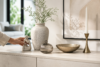 Assorted ornaments styled on shelves and tables in a modern home interior