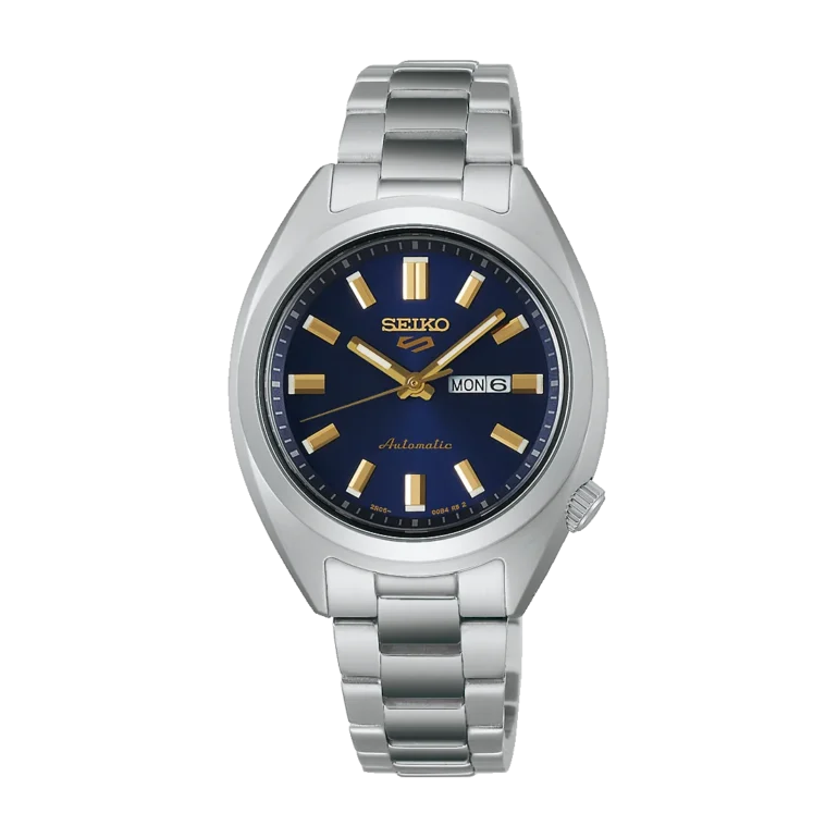 A silver metal Seiko watch with a blue dial, gold hour markers, and hands, displaying the day and date. The tone is elegant and sophisticated.